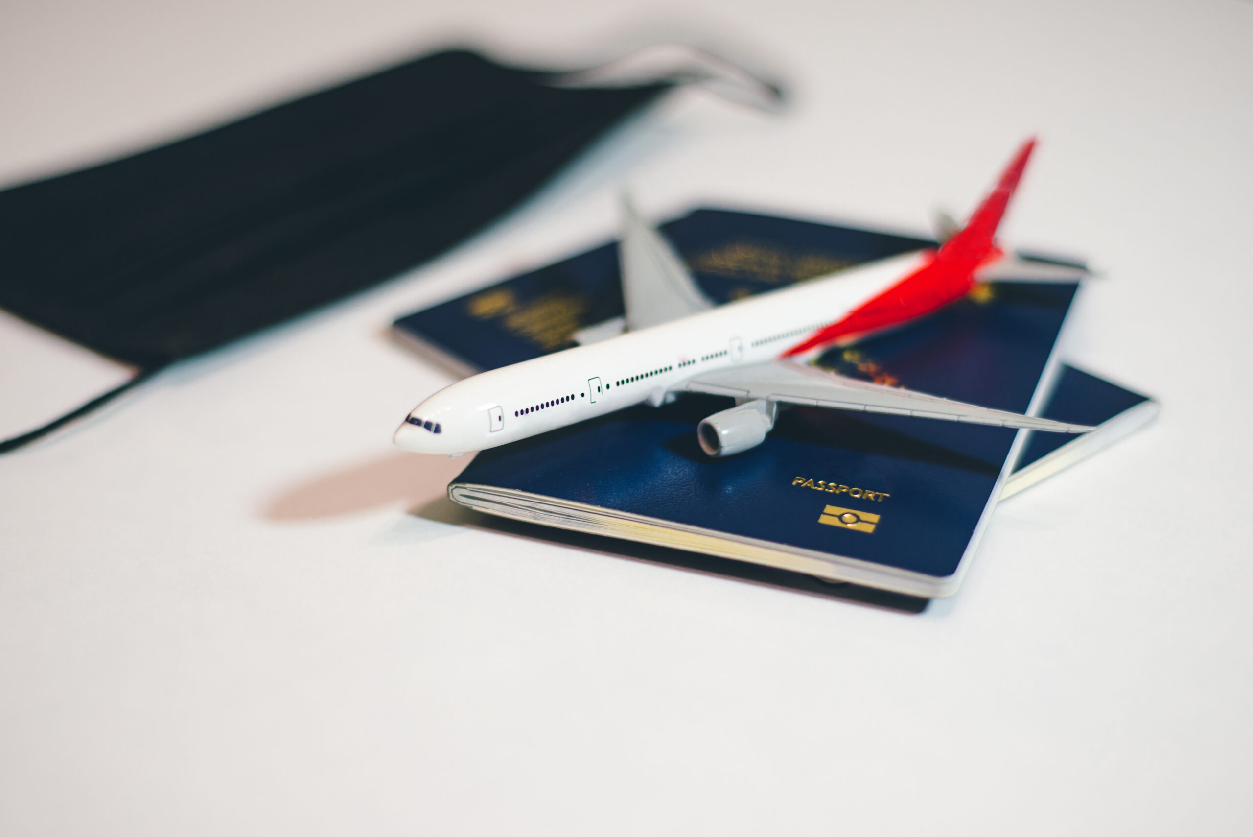 airplane-with-passports-face-mask-table-covid-19-flight-restrictions